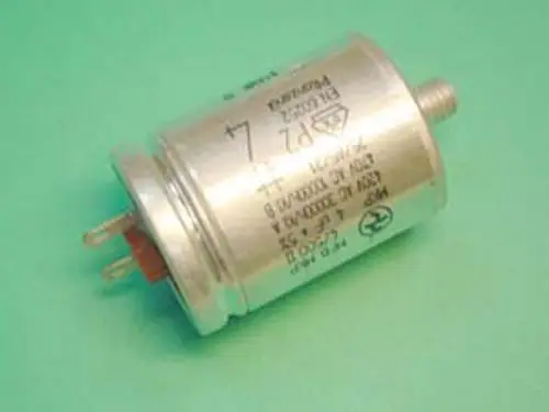 Kondensator in zylindrischer Form, metallisch mit Anschlussstiften. Auf der Oberfläche sind Herstellerinformationen von Remeha sichtbar.